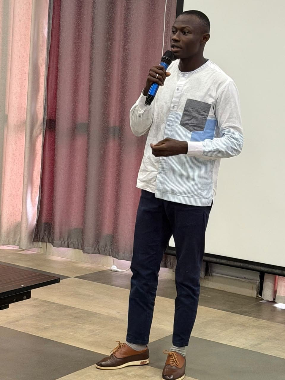 Mamady KEITA en train de présenter, micro en main