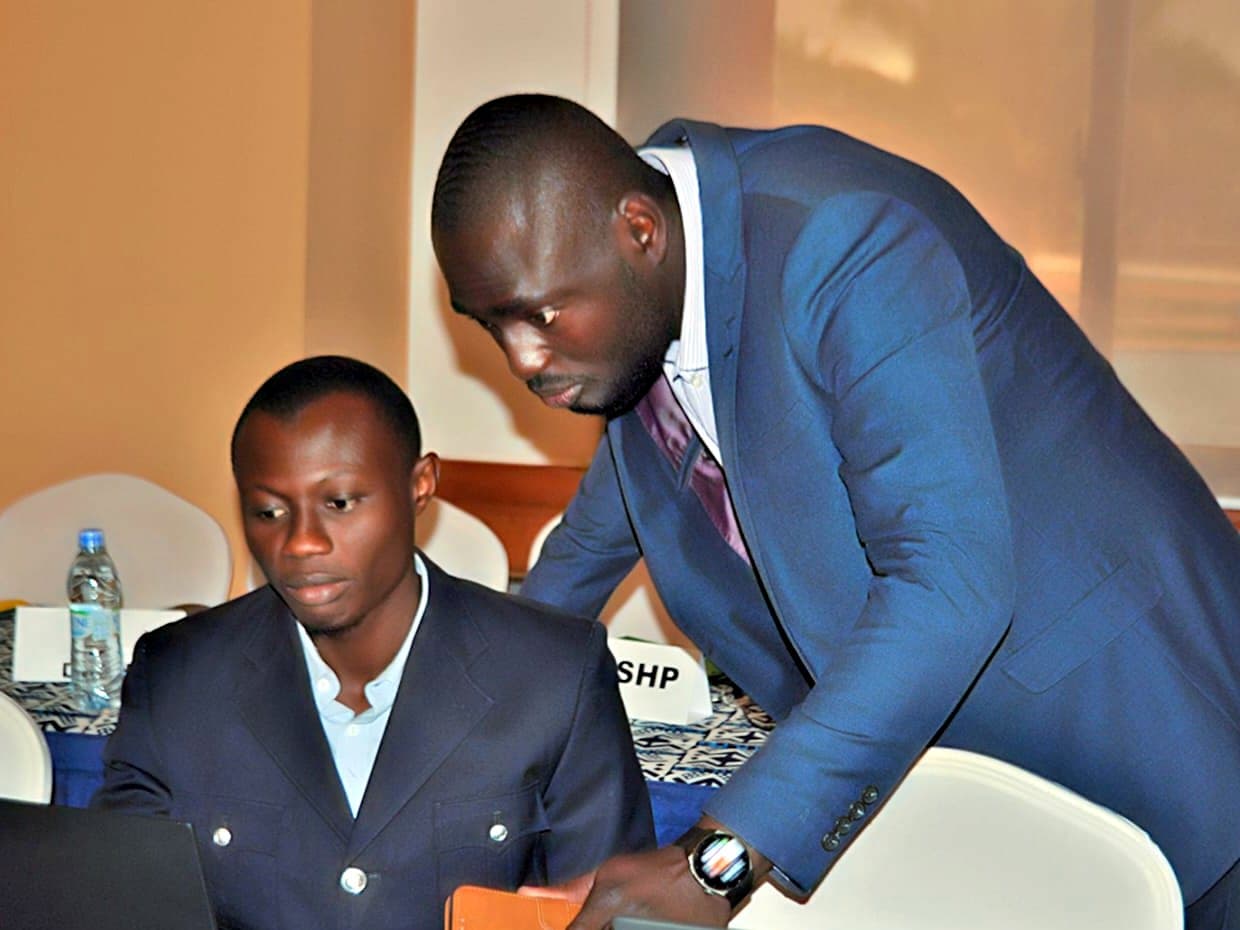 Mamady KEITA en séance de travail sur un ordinateur portable, avec un collègue